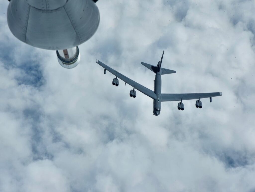 A B-52 bomber flies below a KC-135 tanker.