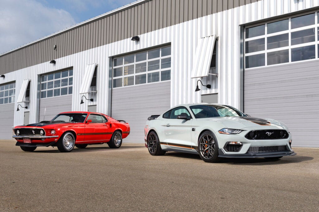 At left, a 1969 Mustang Mach 1. At right, a 2021 Mustang Mach 1. Both are pony cars.