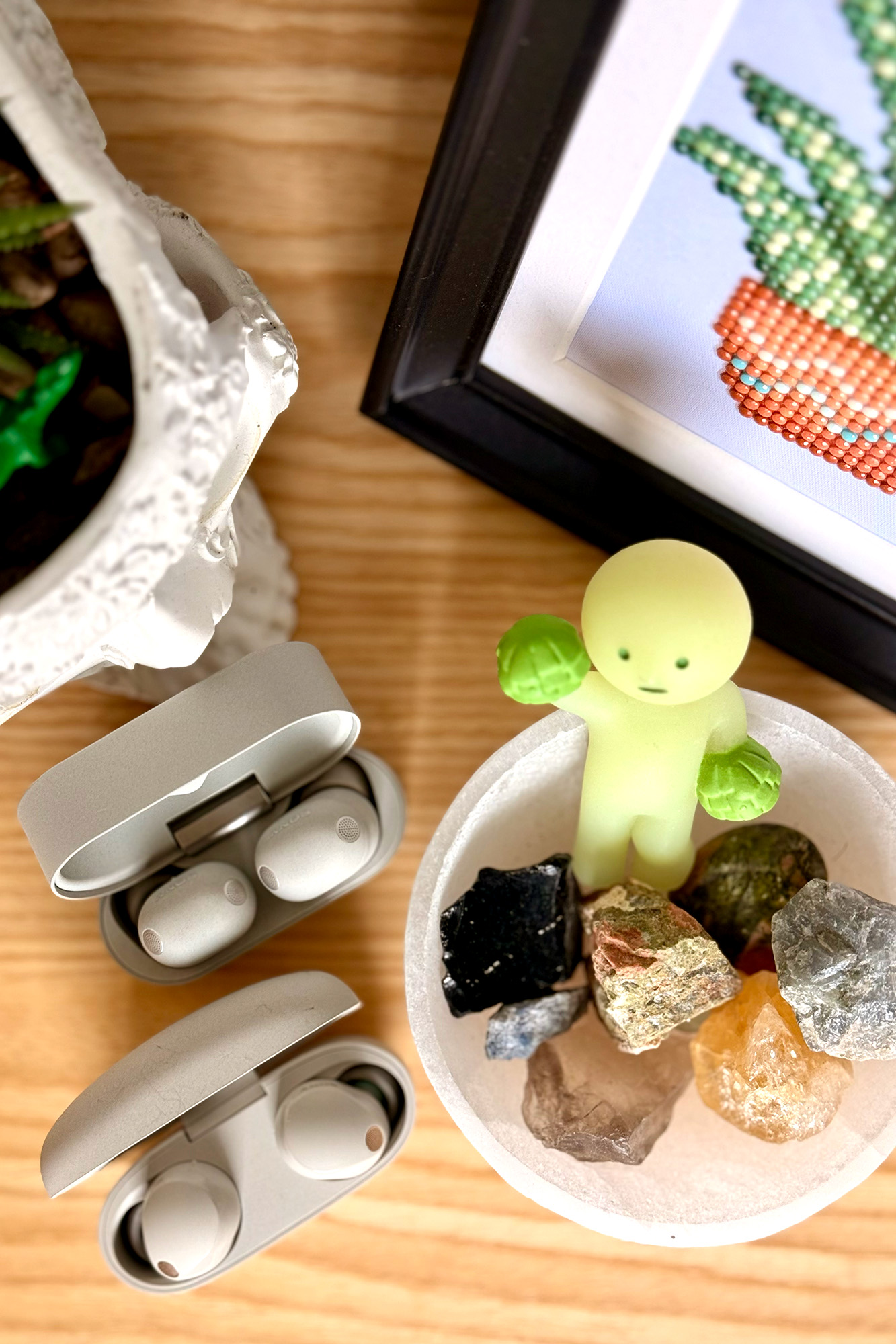 A comparison of the Sony Platinum Silver blob-shaped WF-1000XM5 headphones and the bean-shaped WF-1000XM6 headphones.