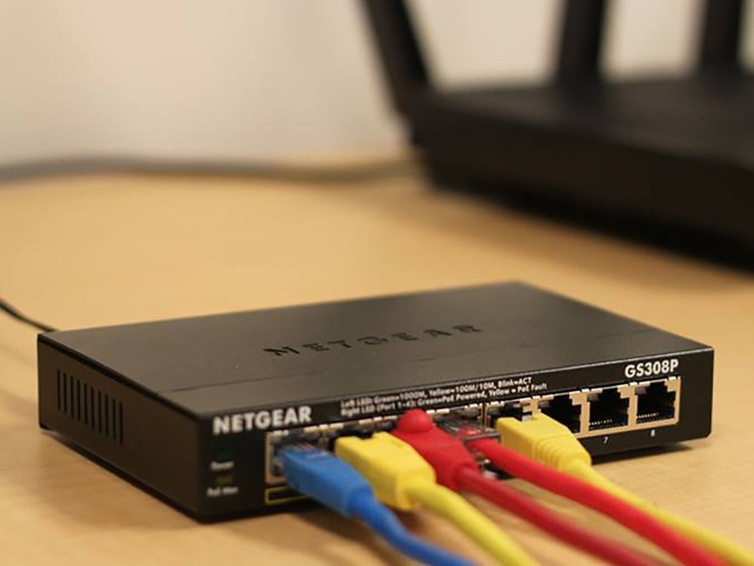 A Netgear router with blue, yellow, and red wires, including an Ethernet connection.