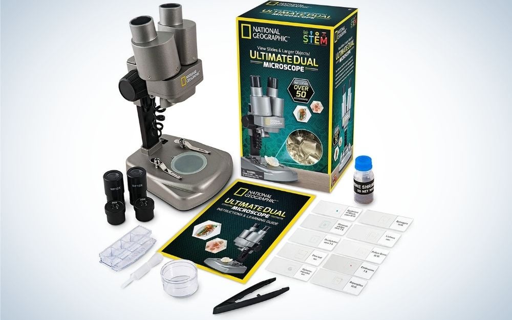 Grey National Geographic Microscope with black small lens and with instructions paper on it.