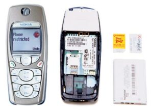 A silver Nokia cell phone (left), the back of the phone with its battery exposed (center), and the battery and two SIM cards (right).