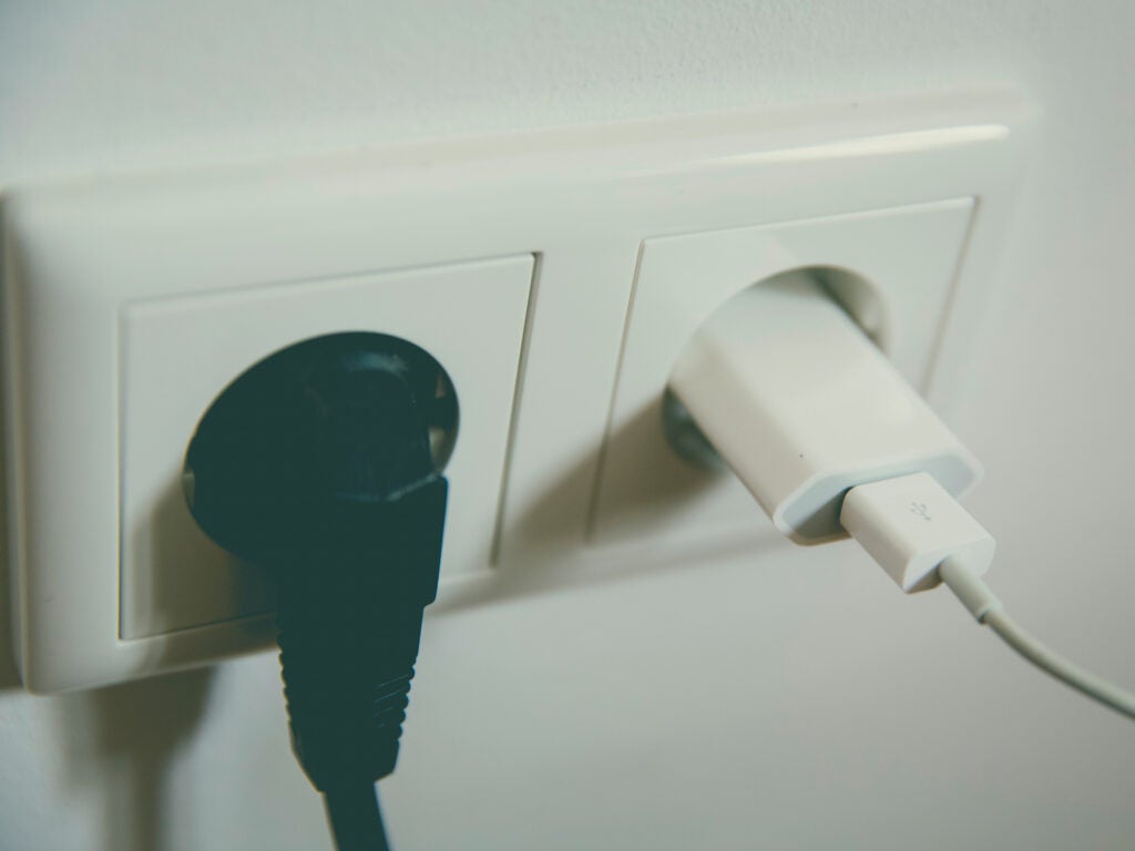 A wall outlet with a USB adapter and another cord plugged into it.