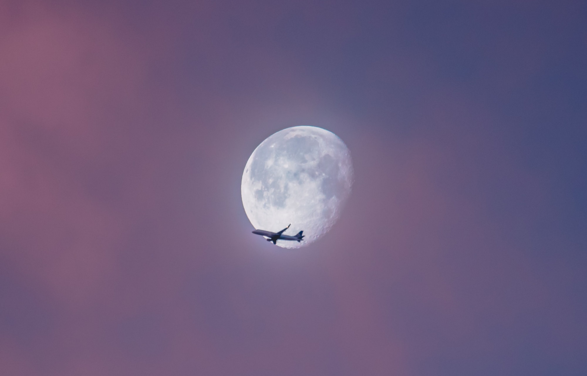 Commercial airplane flying across almost full moon. The question is: Are long flights safe?