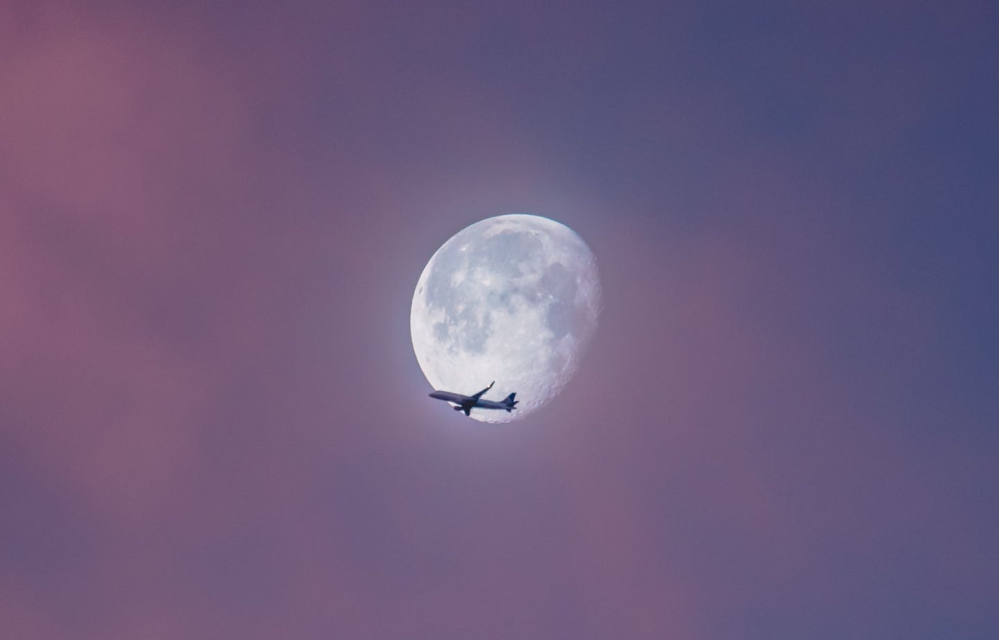 Commercial airplane flying across almost full moon. The question is: Are long flights safe?