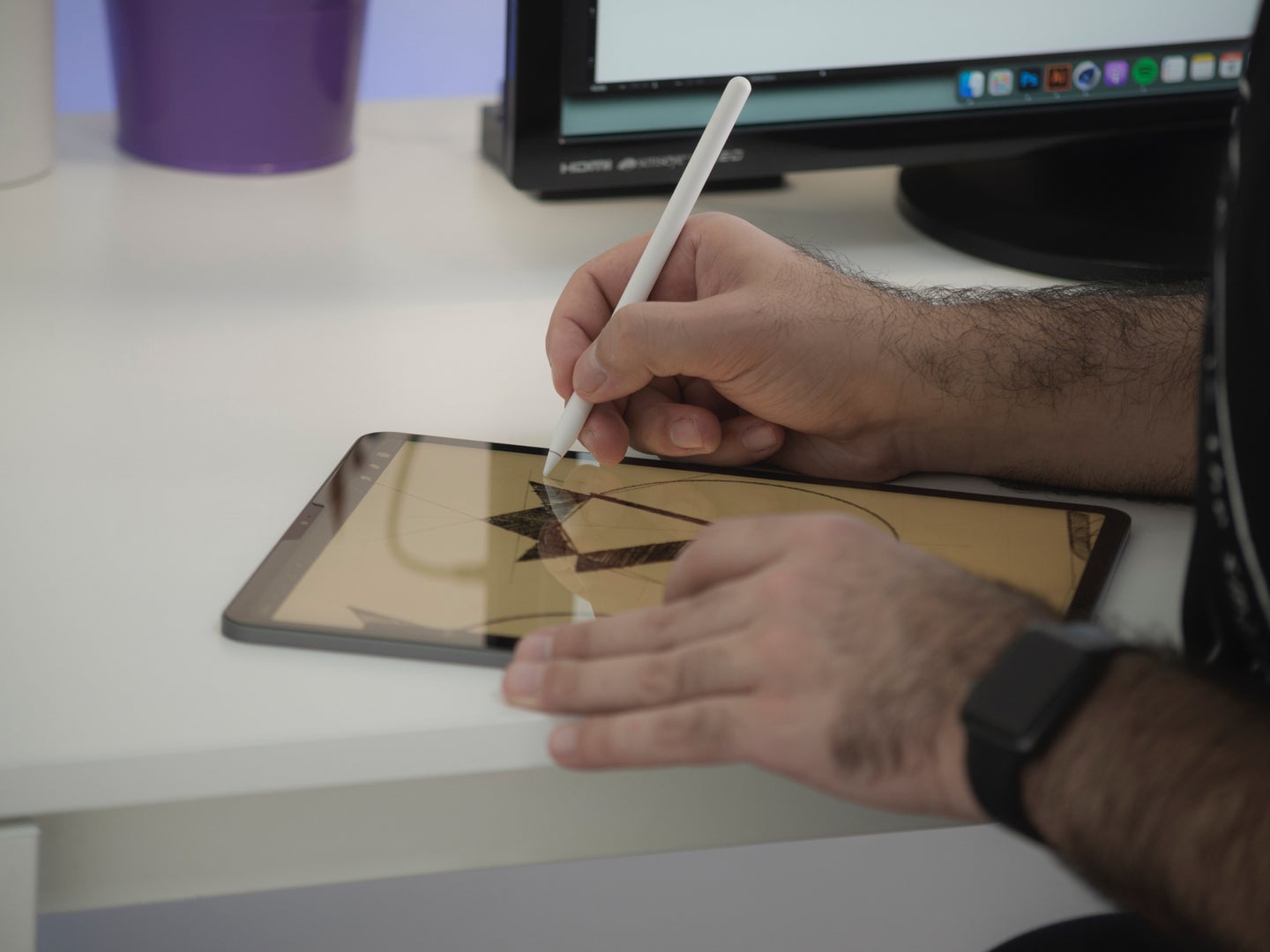 A person using a stylus on a tablet to draw an image.