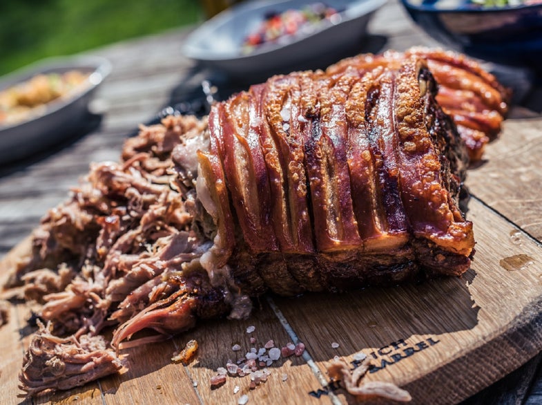 Barbecue pulled pork on a wood tray on a picnic table