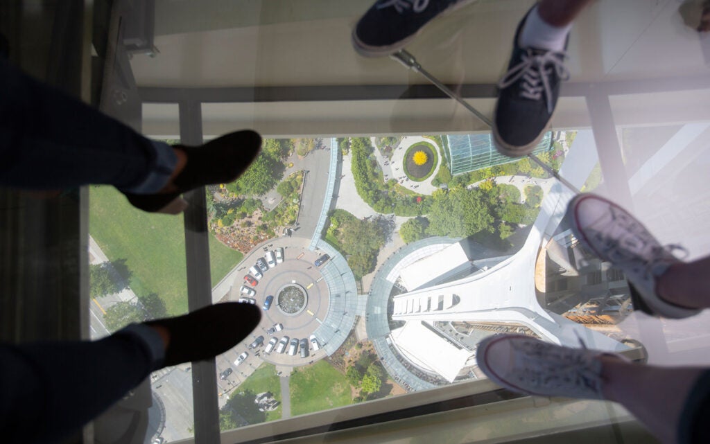 People standing on the world's first revolving glass floor the Loupe on the Space Needle