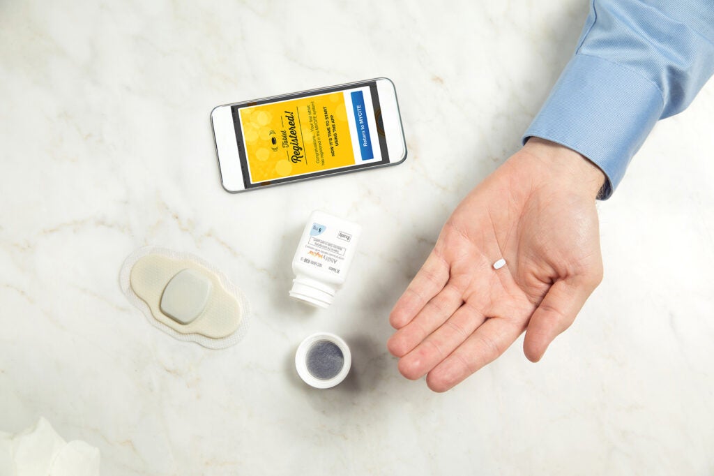 a man holding the Abilify MyCite pill by Otsuka America Pharmaceutical & Proteus Digital Health