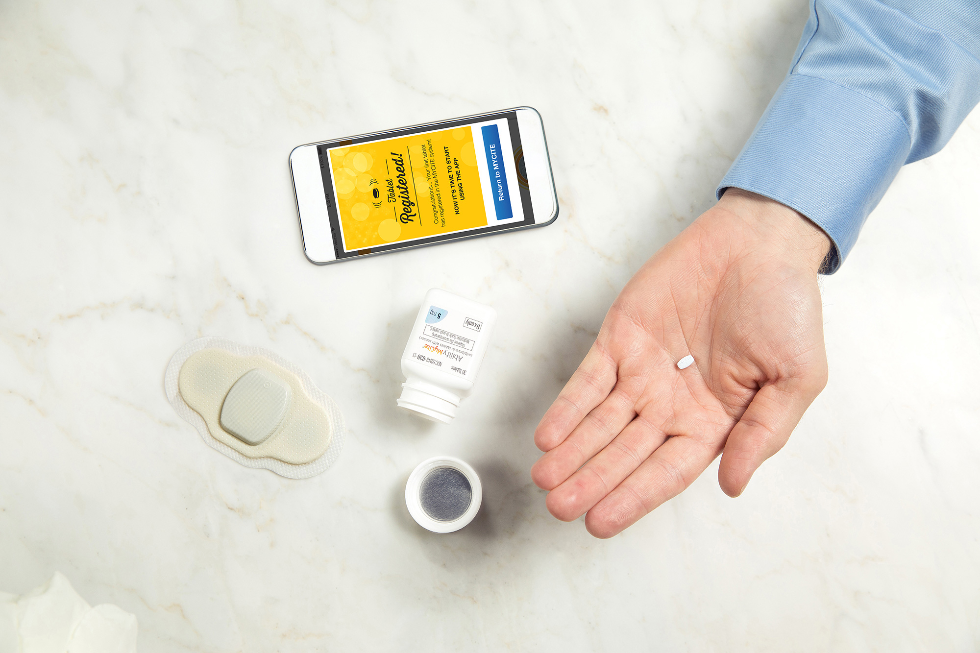 a man holding the Abilify MyCite pill by Otsuka America Pharmaceutical & Proteus Digital Health