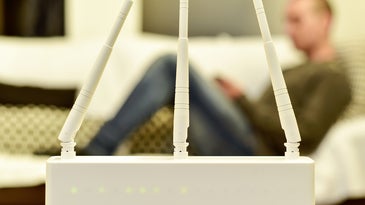 White wireless router in front of person on a couch