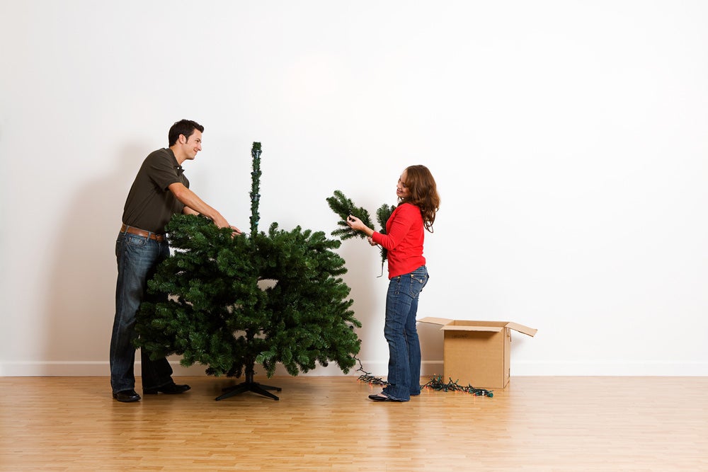 couple building an artificial christmas tree