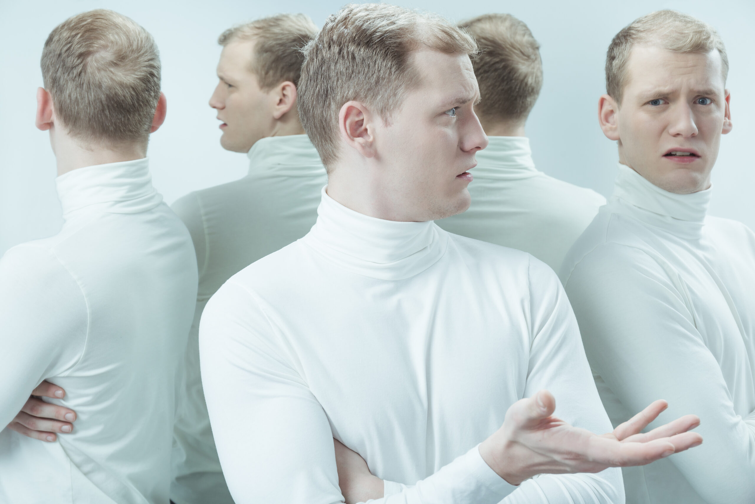 five identical men in white turtlenecks look confused