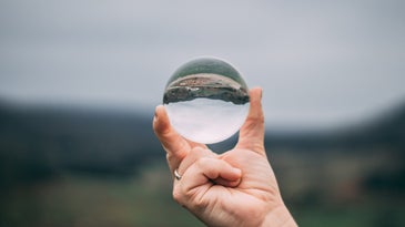 a hand holding a glass sphere