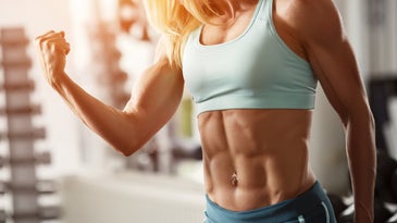 a blond woman with lots of muscles flexes for the camera 