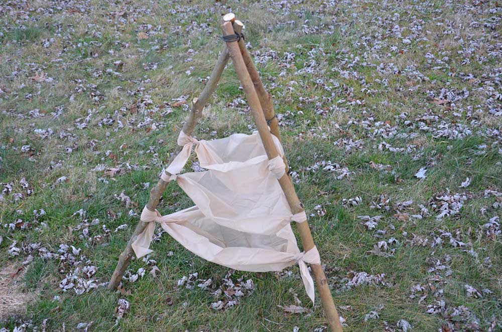 a water filtration teepee made of sticks and cotton