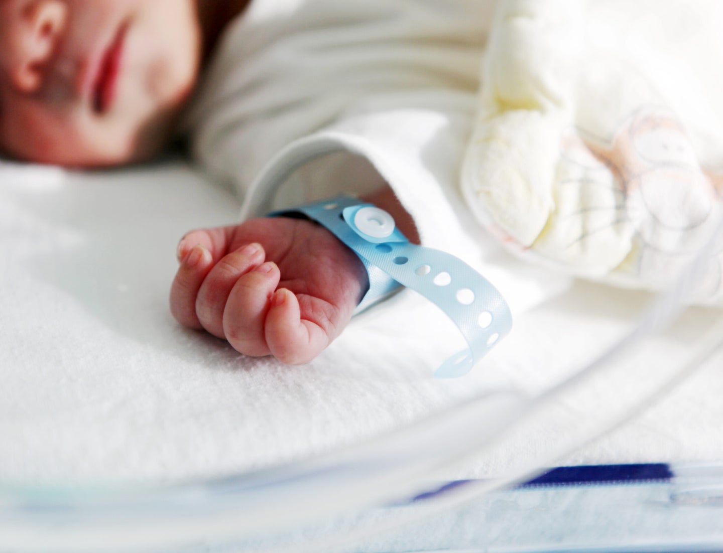 a newborn baby's wrist with a hospital bracelet on it