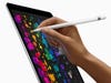 A person using an Apple Pencil stylus on an iPad Pro.