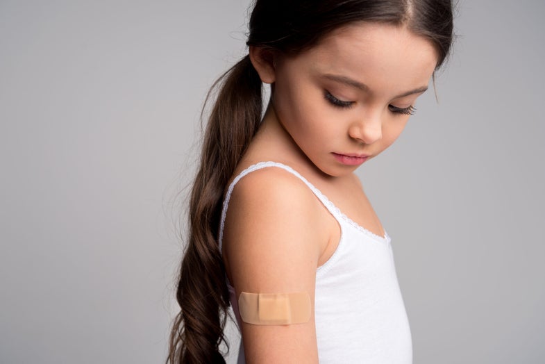 a little girl with a bandaid on her arm