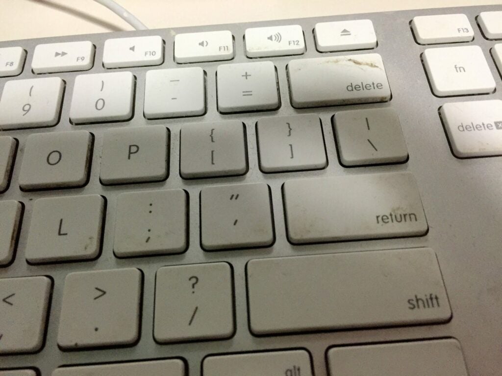 A close-up of a dirty Apple keyboard for a Mac computer.