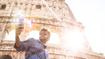 man snapping selfie in front of the Colisseum