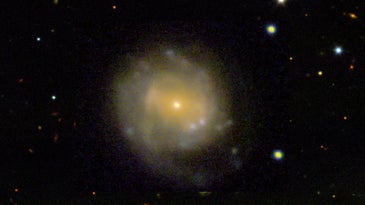 a picture of space with a large circular smear of yellow light at the center 