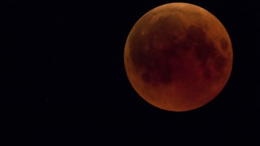 a moon with a red tint due to a lunar eclipse 