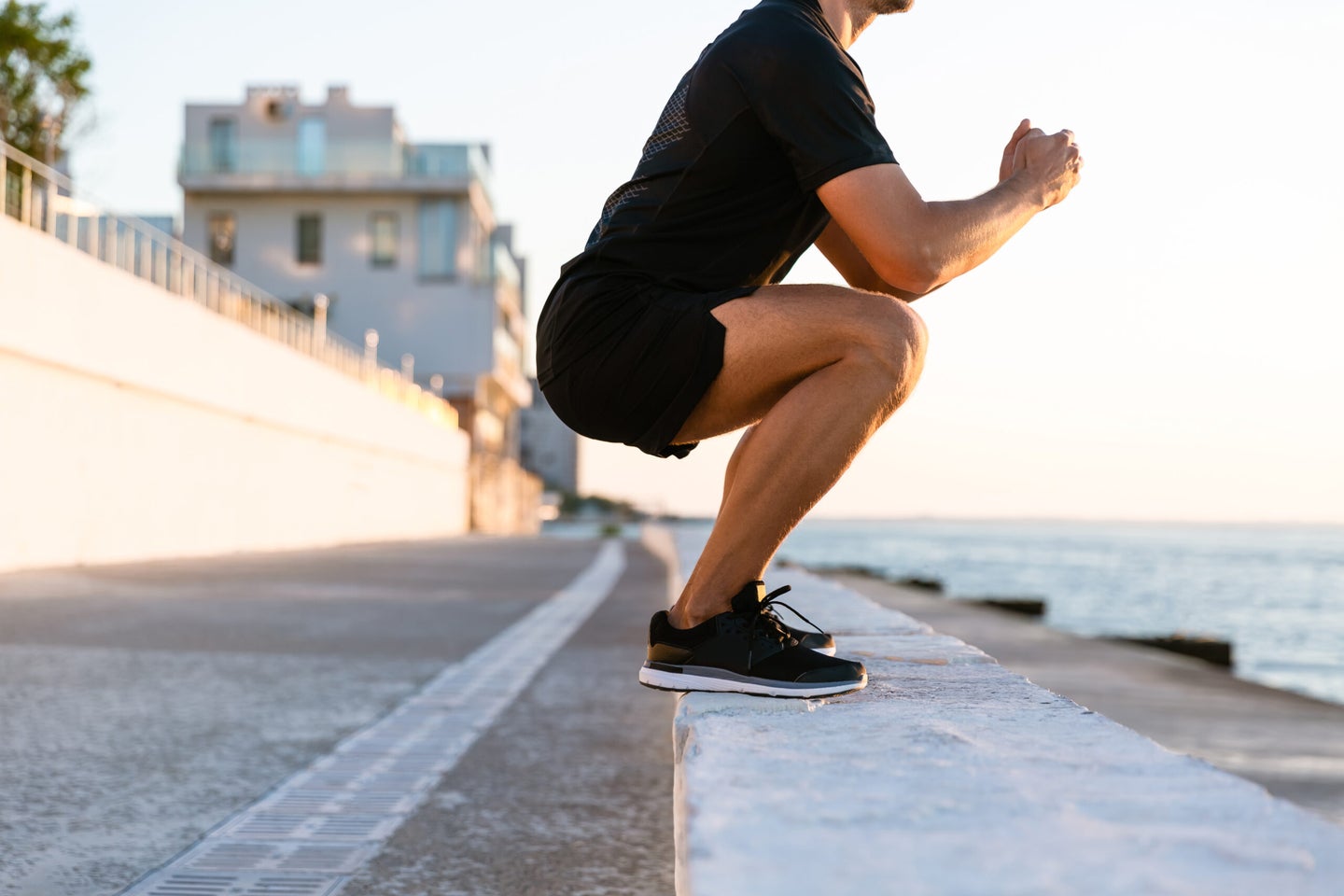 a man doing a squat on a beach