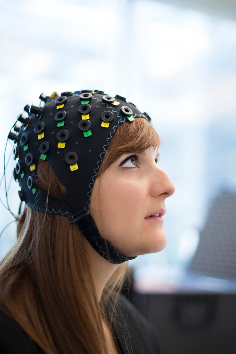 A woman models a brain-computer interface that can help people who are completely paralyzed answer yes-or-no questions.