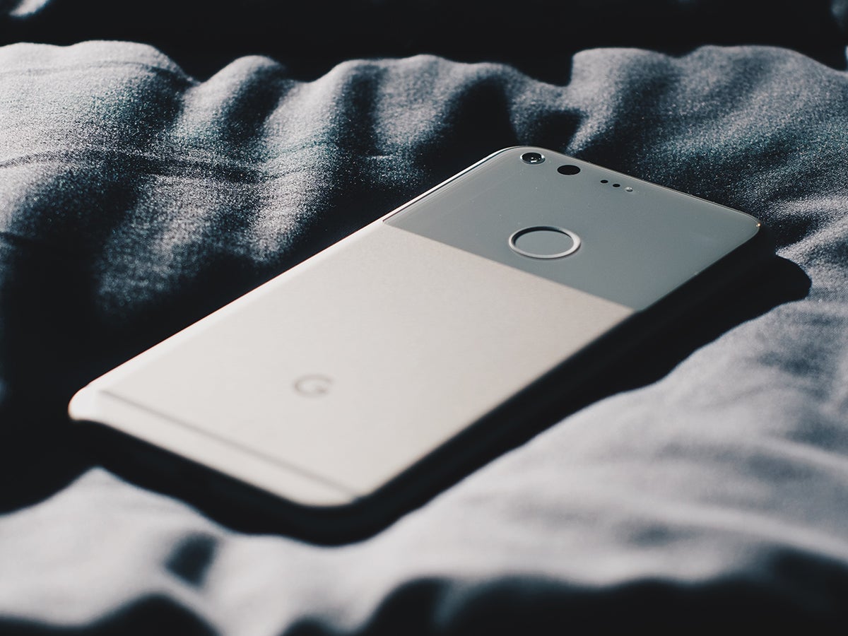 The Google Pixel phone on a gray fabric surface.