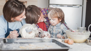 family covered in flour while baking