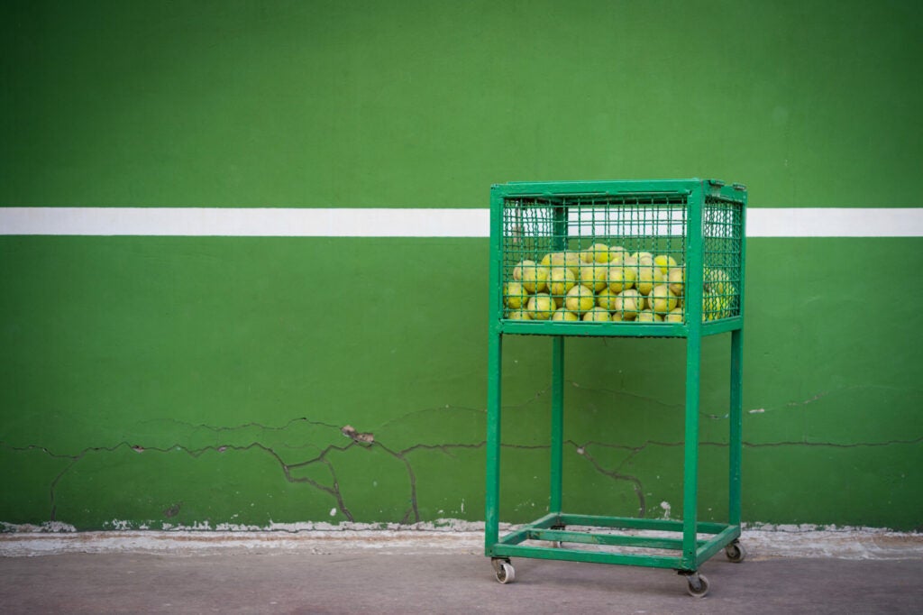 a lonely basket of tennis balls