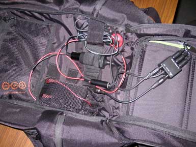 A black backpack filled with black and red wires.