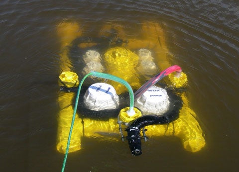 A yellow homemade ROV in some murky water.