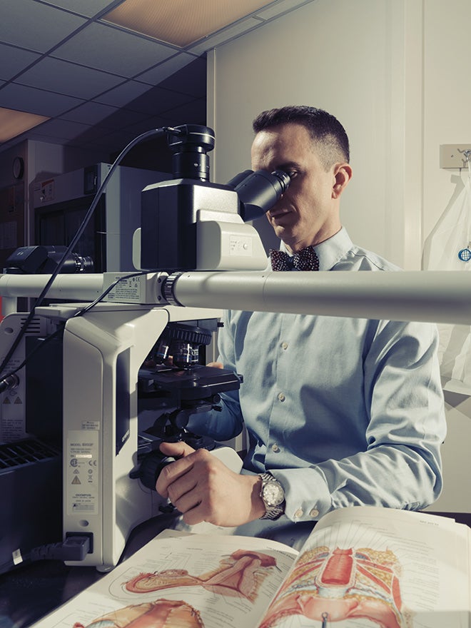Surgical pathologist James Mitchell looking through a microscope