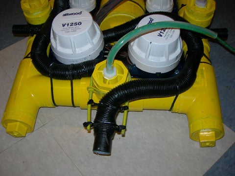 Two bilge pumps that serve as the thrusters of a yellow homemade ROV.