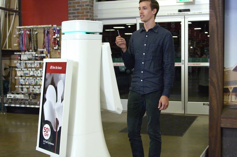 A promotional photo of OSHbot helping a customer at Lowes