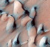 A region of dunes, shown in these three photos, lies near the northern polar ice cap. Each Martian winter, temperatures plummet to –225°F and polar ice caps made of solid carbon dioxide form. When spring arrives and temperatures rise to as high as 65°F, the ice cap evaporates without ever becoming liquid, a process called sublimation. The outlying crescent-shaped dunes [left], which were formed by wind blowing from south to north, defrost by the same process.