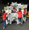 In this traveling geometry exhibit and playspace, children roam through walls of torqued cubes, parabolic curves and wavy mirrors; play with stacked forms and glowing building blocks; and climb gyroids and a stellated rhombic dodecahedron. They might even learn some math as they do.