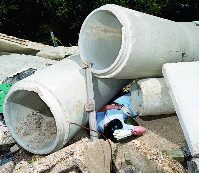 A victim awaits rescue on an 11,000-square-foot pile of concrete. More victims lie beneath the rubble in engineered tunnels.