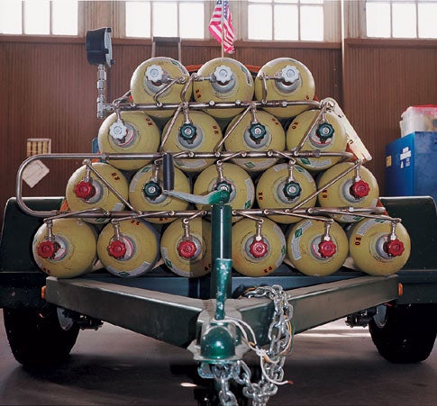 <em>Resting on a trailer are canisters of nitrogen and helium gas, which are used during engine tests to pressurize the kerosene-and-liquid-oxygen fuel mixture for the XR-4K5.</em>