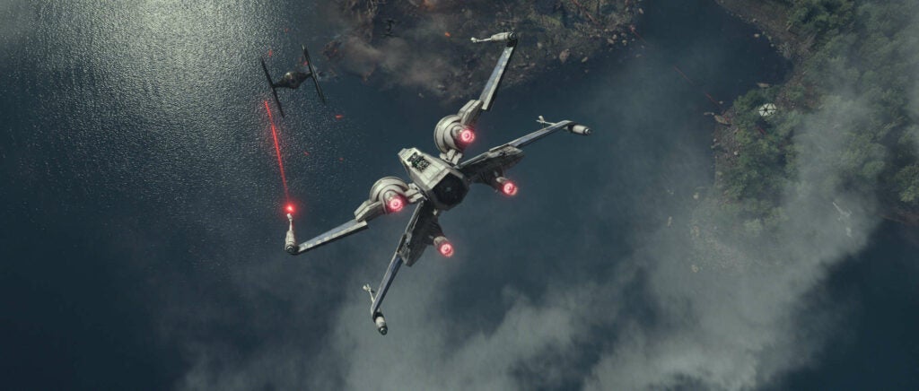 An X-Wing T-70 does battle with a TIE fighter in *Star Wars: The Force Awakens.*