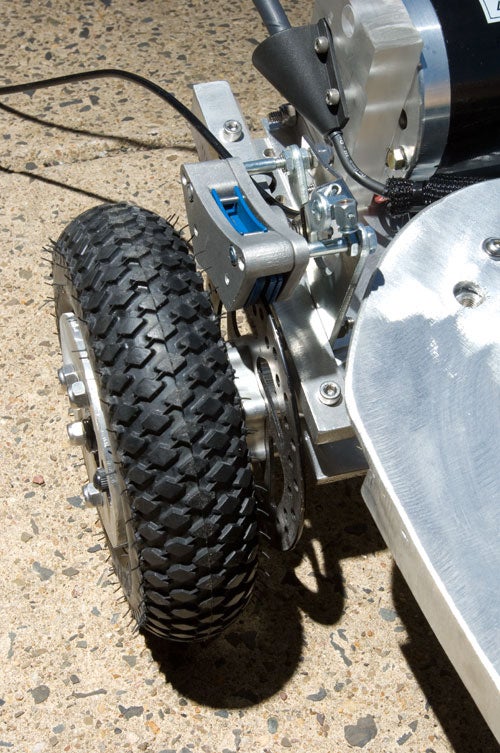 The back wheel of a motorized skateboard, showing a disc brake.