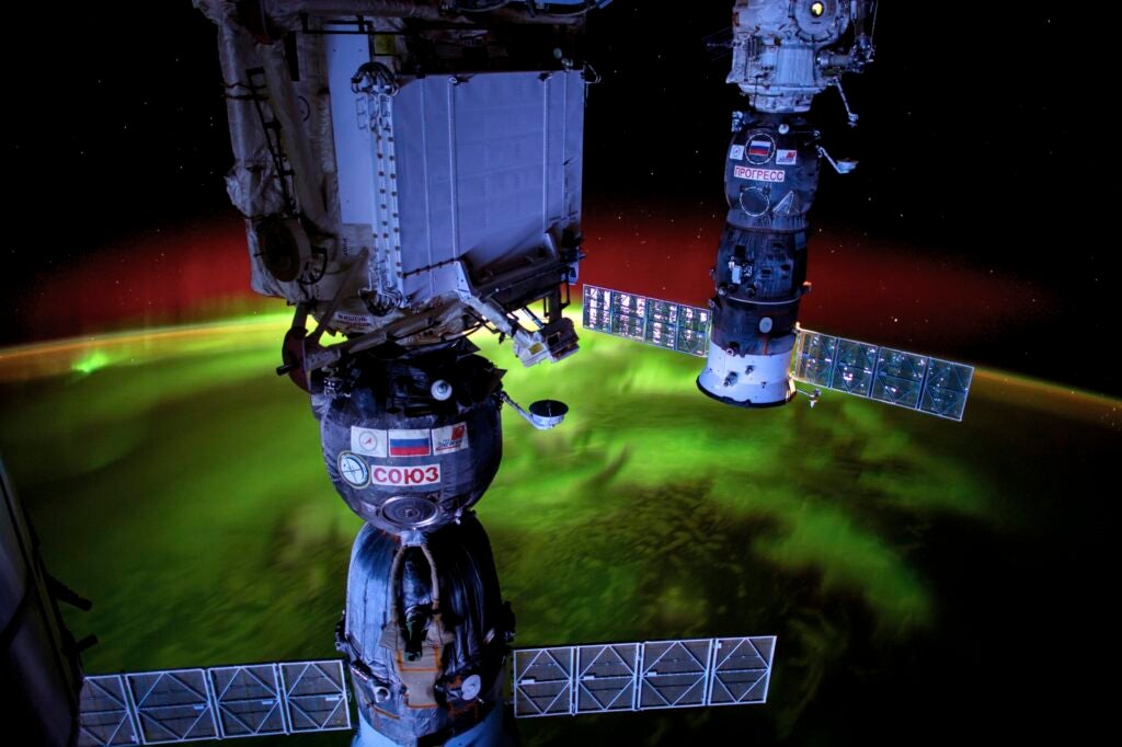 space stations over aurorae