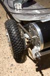 A motorized skateboard's rear axle, with a chain on it.