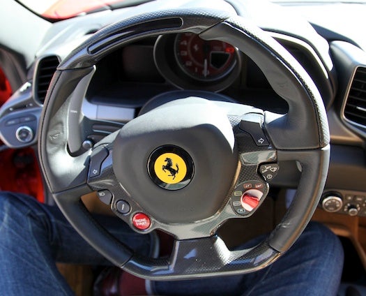 Looking straight out of an F1 cockpit, the steering wheel has buttons for everything from turn signals to wipers to traction control; no stalks to block your grip of the huge metal paddle shifters behind.