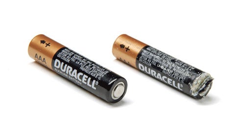 Two Duracell batteries. One has white crust on it.