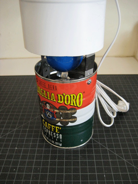 A coffee can over a blue light bulb that's inside a plastic jug as part of a homemade bug zapper.