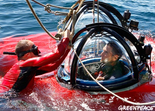 Sub pilot and Greenpeace scientist John Hocevar watches as <em>Arctic Sunrise</em> electronic technology officer —and seasoned snorkeler— Neil Brewster attaches tag lines to help guide the sub back onto the ship's deck after a dive.
