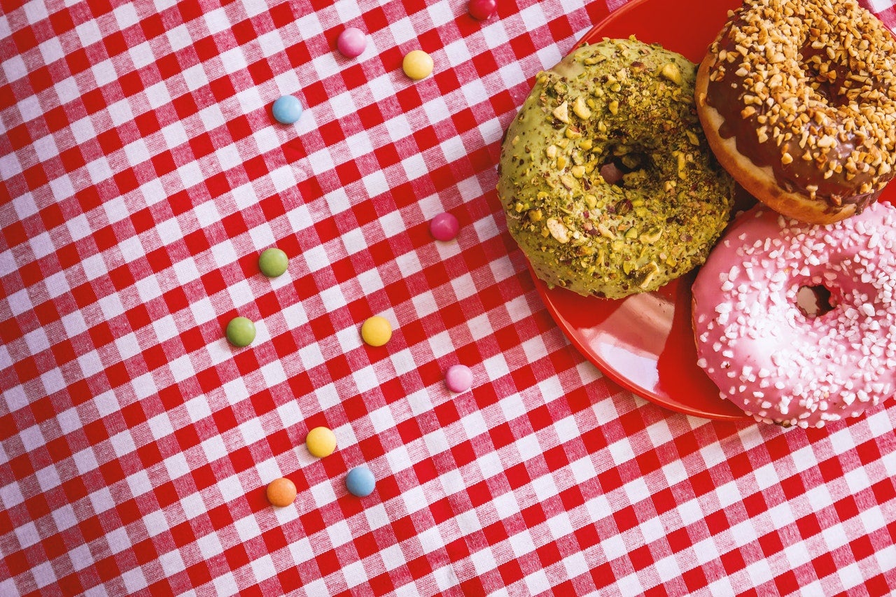 Three donuts on a checkered tablecloth
